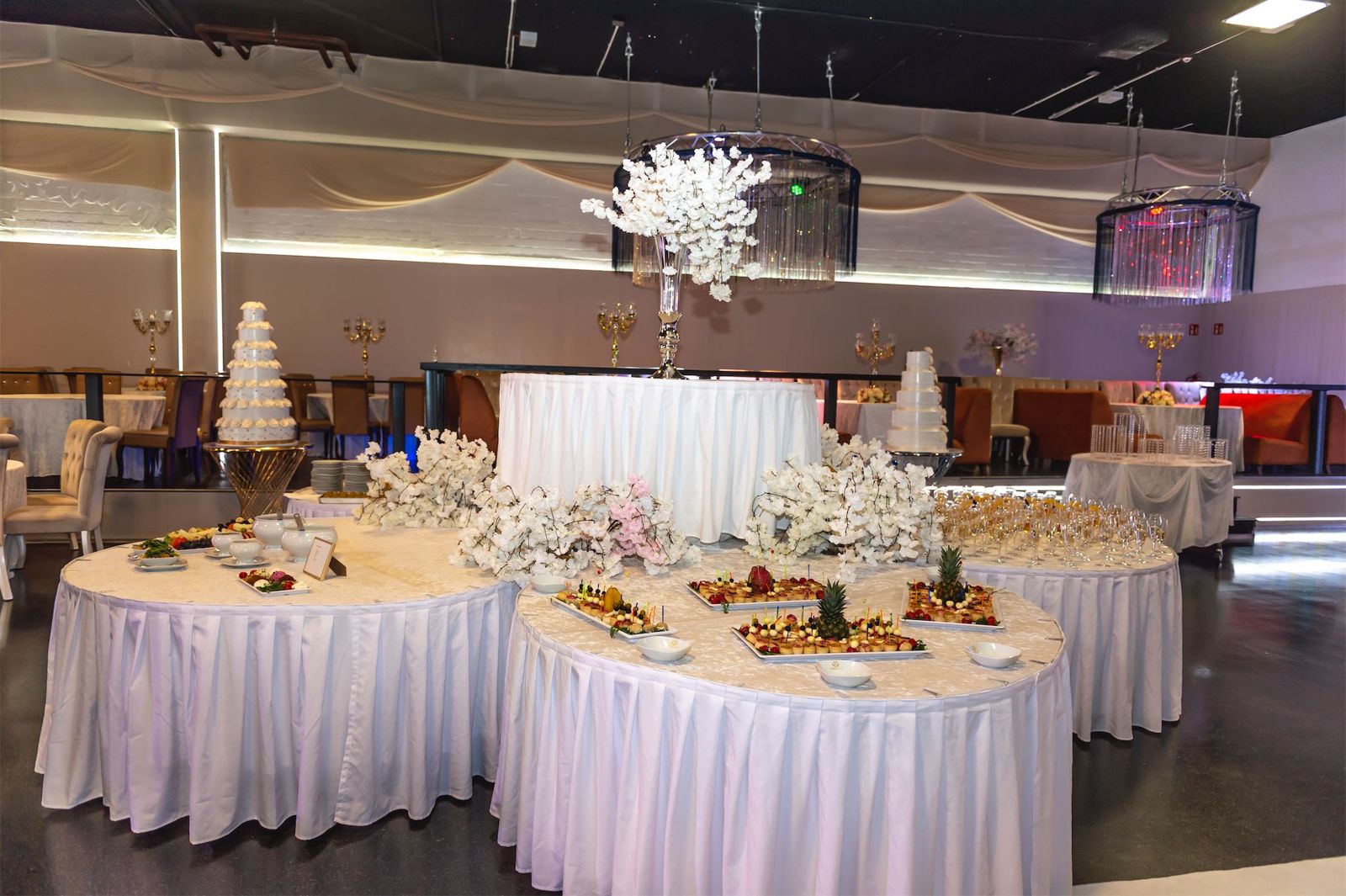 Buffet mit weißer Blumendekoration und Hochzeitstorte